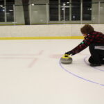 Heather Barclay tests the ice conditions at the at the Morgantown Ice Arena Saturday night by curling a stone down the ice.